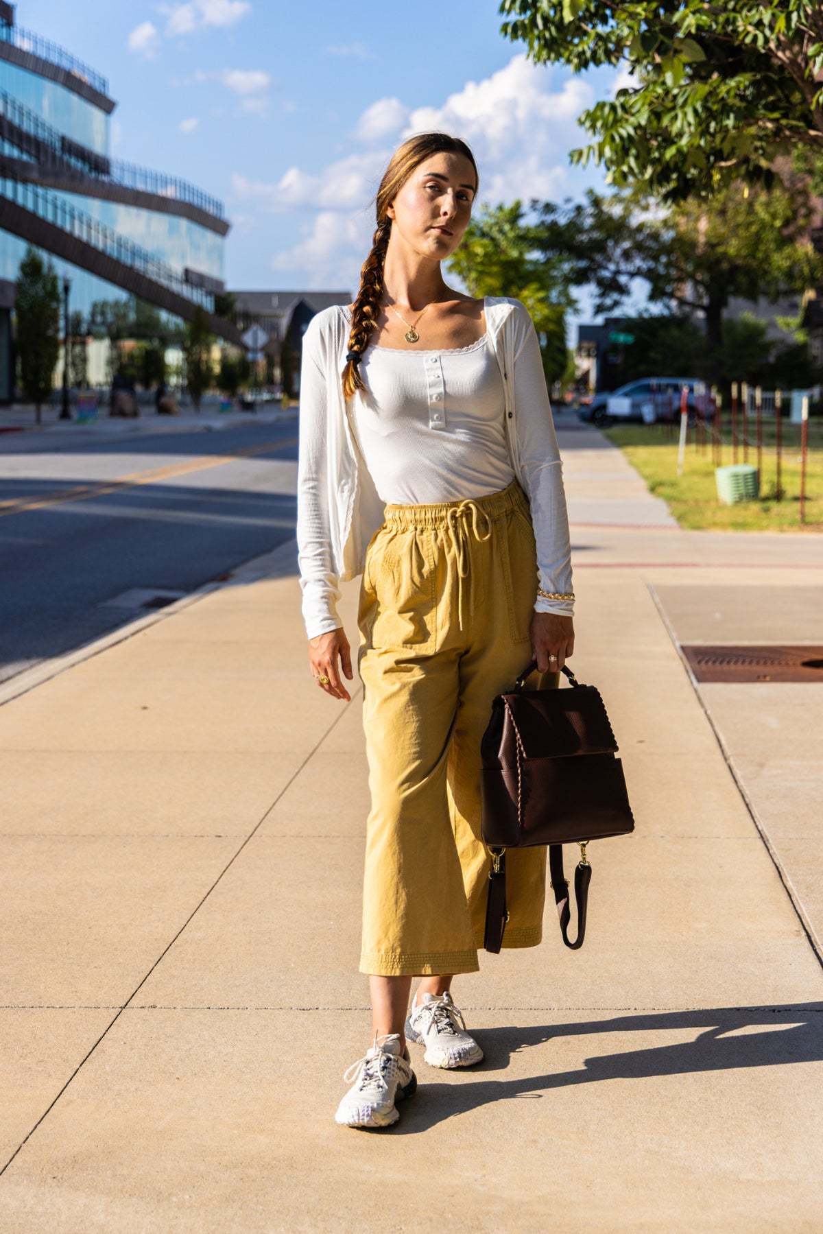 Uliana Leon models Bella Emilia's mustard wide-leg pants on a downtown Bentonville sidewalk.