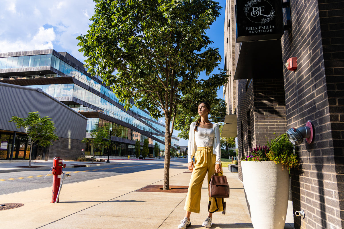 Full-length lifestyle image of Uliana Leon wearing mustard wide-leg pants in Bentonville.